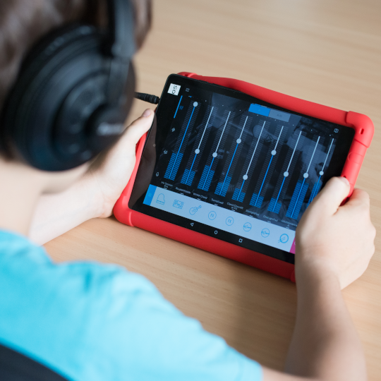 Kind mischt Musik auf einem Tablet beim Pfingstferien-Workshop