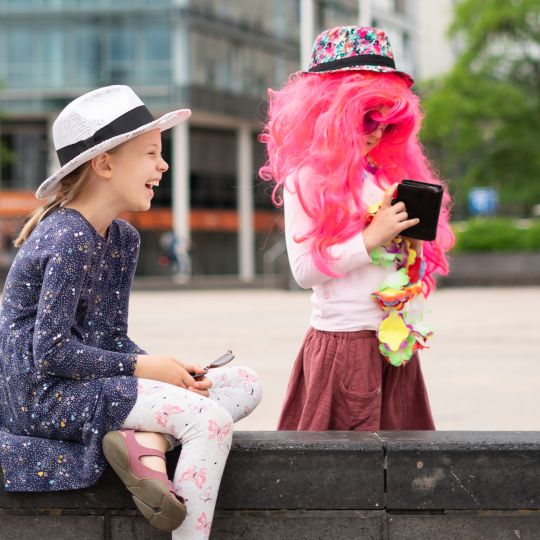 Zwei Kinder mit Tablet und Verkleidung bei einem kreativen Sommerferien-Workshop