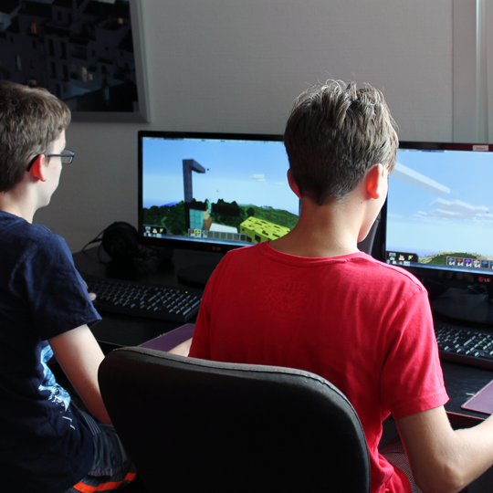 Zwei Kinder spielen Minecraft am Computer bei einer LAN-Party zum Kindergeburtstag
