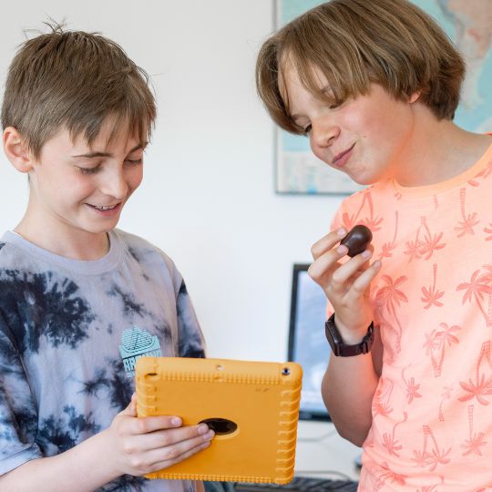 Zwei Jungs mit Schokokuss und Tablet in Aktion bei der Geburtstagsrallye