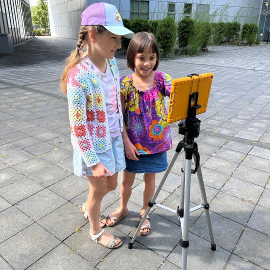 Zwei Mädchen drehen mit einem Tablet ein Video beim Kindergeburtstag