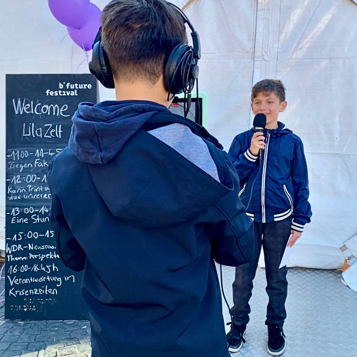 Kinder sind als Junior Journalists unterwegs und führen Interviews