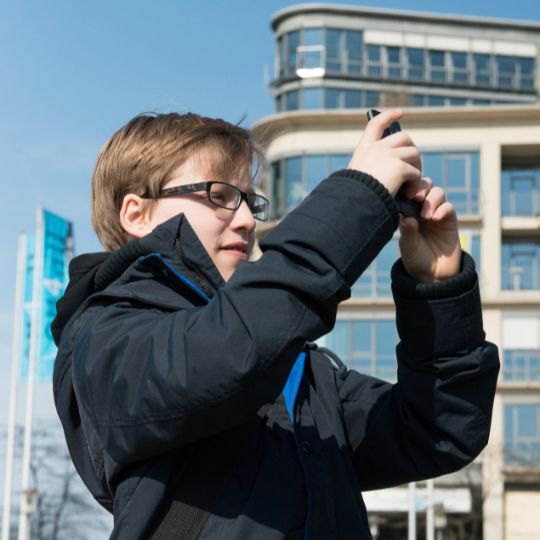 Mädchen macht ein Selfie mit ihrem Handy im kreativen Medien-Workshop