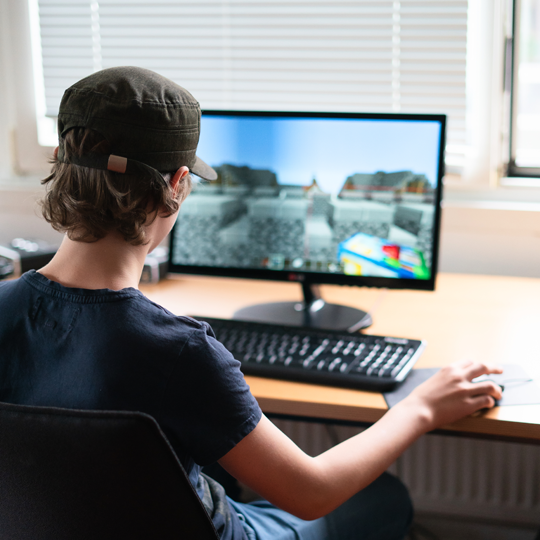 Junge spielt Minecraft am Computer in einem Games-Workshop