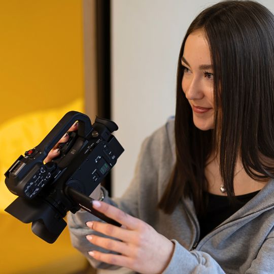 Mädchen mit Videokamera und Junge mit Audio Equipment bei Videoproduktion