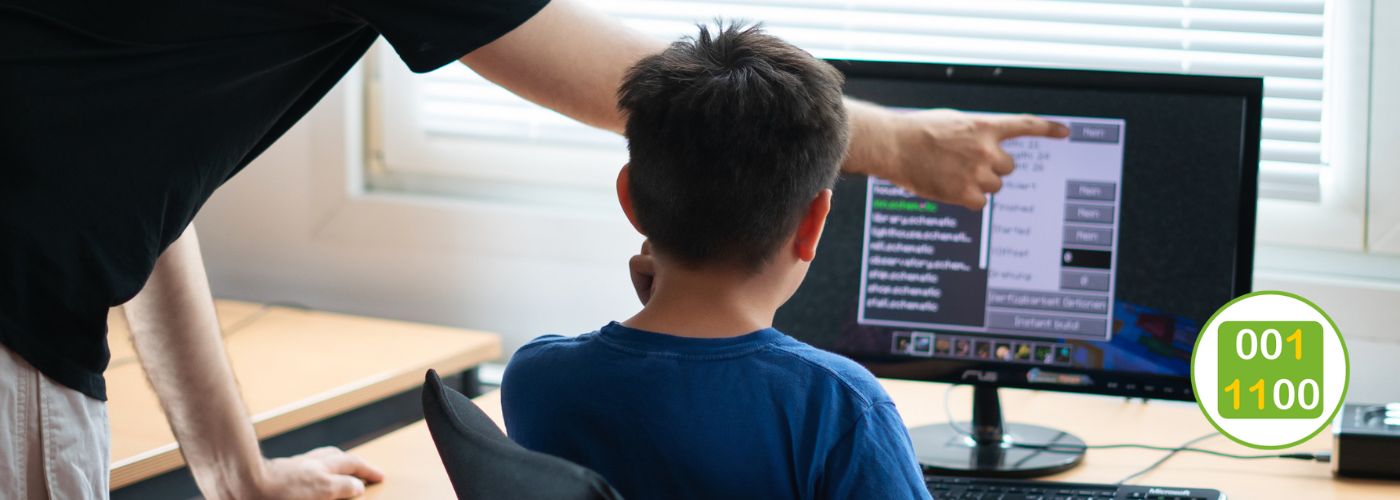 Dozent unterstützt Jugendlichen bei der Spieleprogrammierung im Medien-Workshop.